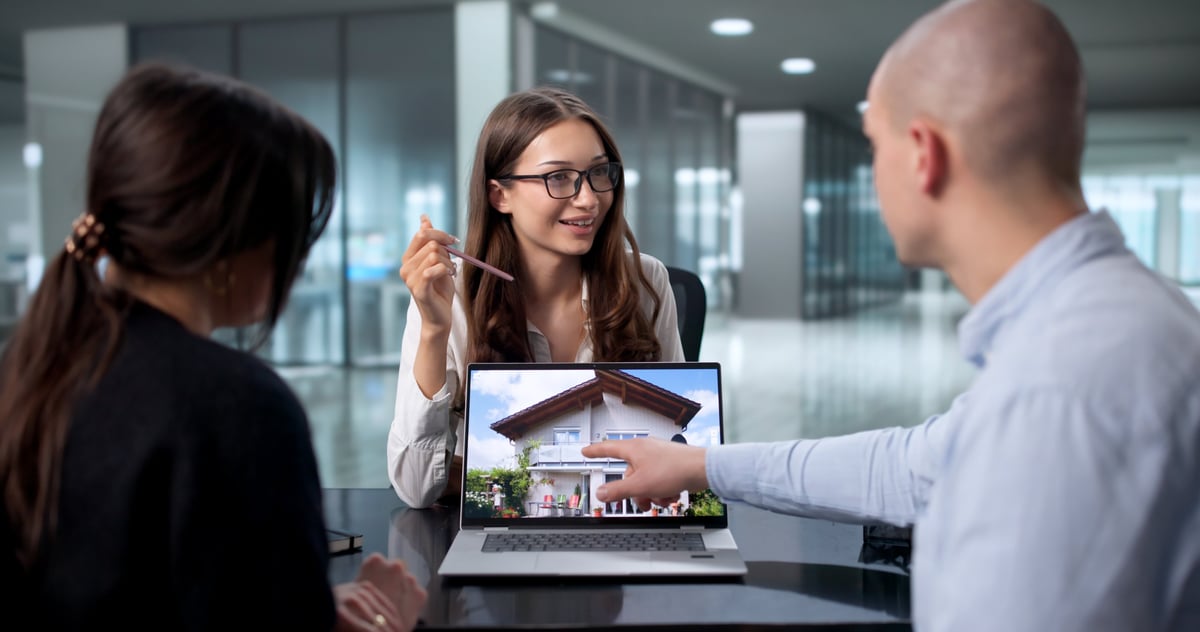 Young Couple Consult With Real Estate Agent About Buying First Home.