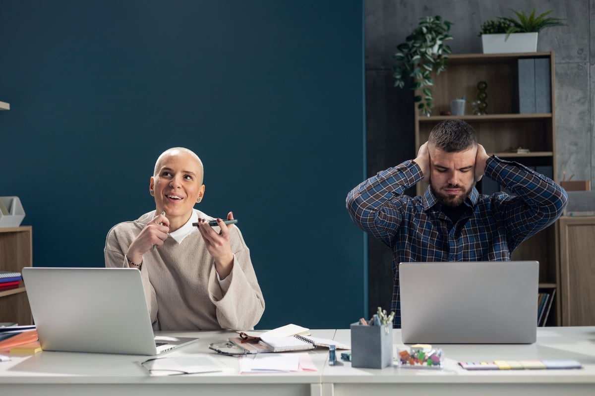 Coworker speaking loudly on phone creating office noise distraction for concentrating colleague