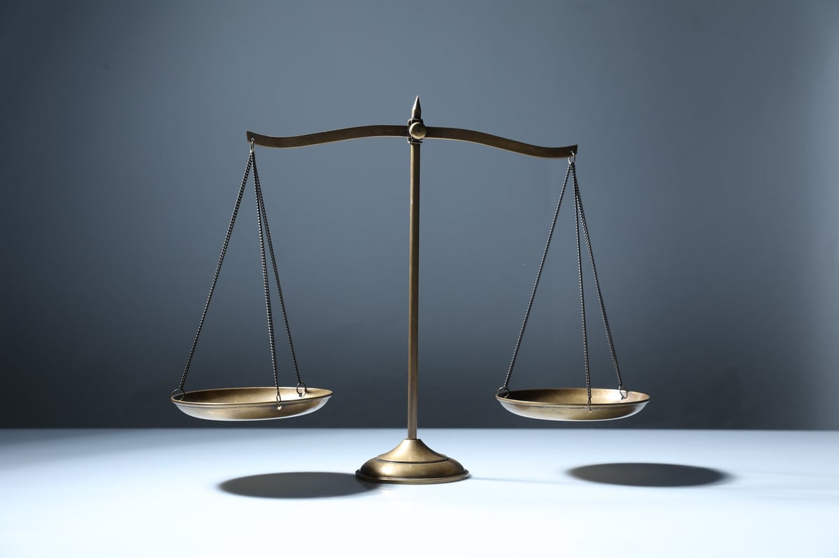 Golden scales of justice on grey background