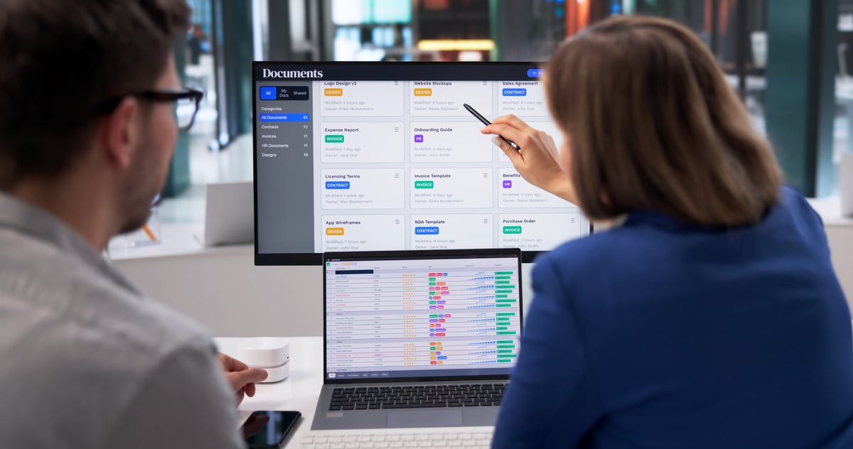 Young Professional Managing Spreadsheets And Documents Across Multiple Screens In Office Setting
